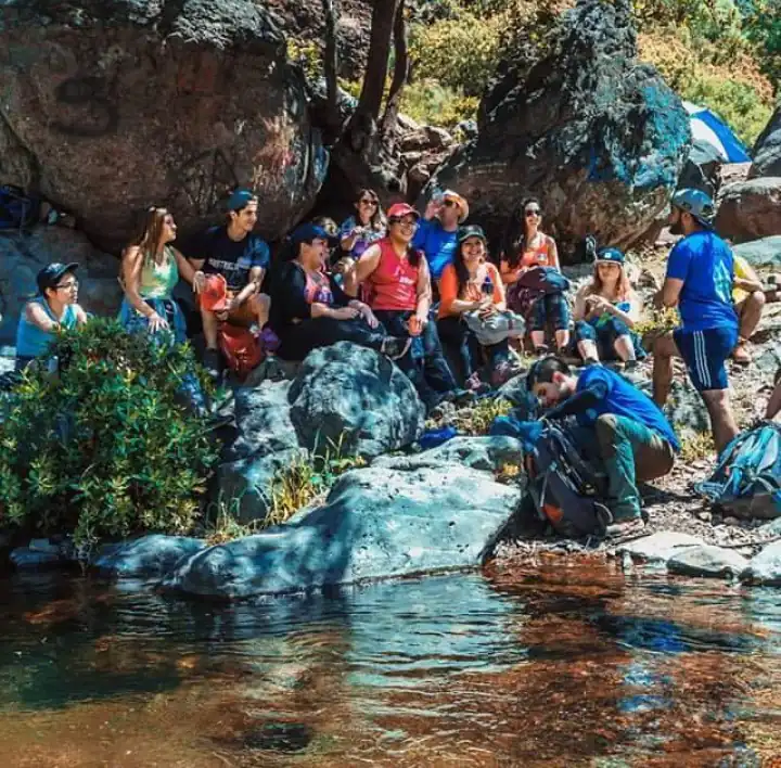 Grupo descansando sobre las rocas junto a un pozón